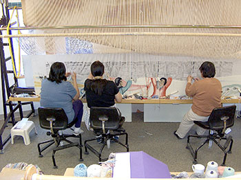 Pangnirtung weavers Oolassie Akulukjuk, Kawtysie Kakee and Anna  Etuangat work on the huge tapestry commissioned from the Uqqurmiut weaving studio by Inuit Tapiriit Kanatami and the Vancouver Organizing Committee for the 2010 Olympic and Paralympic Winter Games. (PHOTO COURTESY OF THE UQQURMIUT CENTRE FOR ARTS AND CRAFTS)