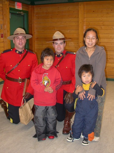 RCMP members Dave Brown and Greg Redl stand with Katie Anivilok and her sons Andrew Anavilok and Alexander Anavilok stand togther Oct. 19 in Cambridge Bay’s Luke Novoligak community centre where the two members were honoured for quick action on July 9, which saved seven-year old Andrew from drowning. (PHOTO BY VICKI AITAOK)