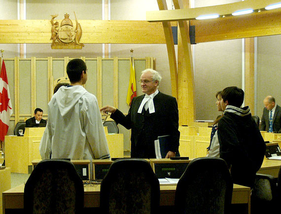 John Quirke, the clerk of the Legislative Assembly, issues instructions to pages for the opening of the assembly's second session Oct. 19. It began with Finance Minister Keith Peterson warning overspending at the Nunavut Housing Corporation threatens Nunavut's tiny budget surplus. (PHOTO BY CHRIS WINDEYER)