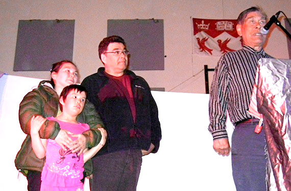 May 31, a proud evening for everyone attending a gala at Sautjuit School in Kangirsuk to celebrate the achievements of their youth and honour those who saved their fellow citizens from drowning and dogs. Here, Martha Keleutak, holding her daughter, listens with Joseph Annahatak, the vice-chair of the Kativik Regional Government, to Eyestiak Simigak. Simigak received an award and a gift of hunting equipment, for his role in saving Keleutak's daughter from an attack by four vicious stray dogs last December. The six-year-old was walking home from school when four loose huskies approached her and started to bite her. Simigak and his son Simonie, also honoured May 31, pulled her away. (PHOTO BY JANE GEORGE)
