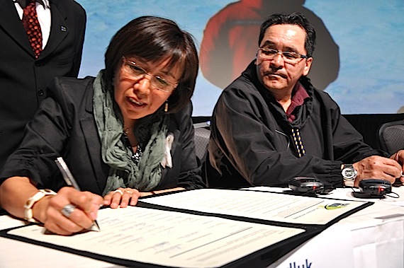 Maggie Emudluk, chair of the Kativik Regional Government, signs the Plan Nord May 9 at the Lévis Congress Centre while Makivik Corp. President Pita Aatami watches. (FILE PHOTO)