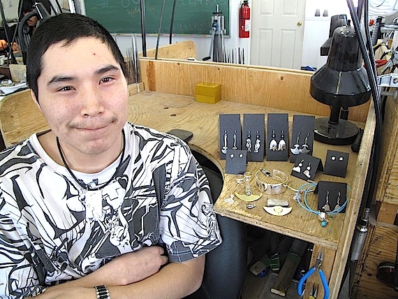Willie Morgan of Kangiqsualujjuaq, a participant in the Inukjuak jewelry workshop, has the use of only one hand, but that doesn't stop him. Morgan produced many pieces of jewelry (seen behind him here) along with Laina Nulukie, Paulosee Nulukie, Jeffery Kadsuluak, James Idlout, Annie Weetaluktuk and Angus Crow. April 28 from 1 p.m. to 4 p.m. they'll be selling their pieces at the workshop located near by the river and airport. (PHOTO COURTESY OF B. DORAIS)