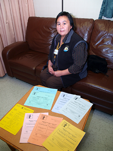 Martha Malliki, an interviewer and greeter aboard the CCGS Amundsen in 2007, displays the various survey forms that participants in the Qanuippitali Inuit Health Survey were asked to fill out. (FILE PHOTO)