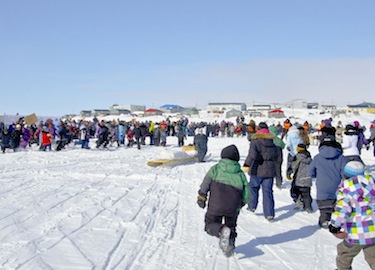 People rush to greet the winners as they cross over the finish line March 27 in Puvirnituq. (PHOTO BY PIERRE DUNNIGAN/ COURTESY OF MAKIVIK CORP.)