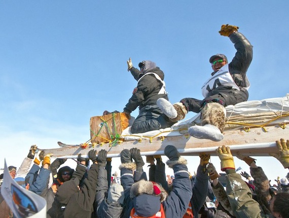 A triumphant arrival: Peter Ittukallak and Juani Nutaraaluk of Puvirnituq are carried on a komatik after they won the 2013 Ivakkak dog team race. (PHOTO BY PIERRE DUNNIGAN/ COURTESY OF MAKIVIK CORP.)