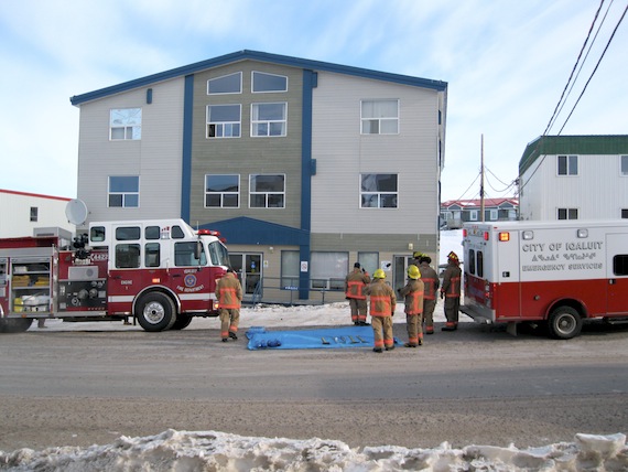 Members of the Iqaluit Fire Department stand by early March 27 as they evacuate an apartment building on Niaquinngusiaq, by the Quick Stop on the way to Apex. A call about smoke alerted the firefighters to the scene at 8:50 a.m. Firemen determined that the smell of burning rubber had been caused by overheated electrical wiring in a private business on the ground floor, fire chief Luc Grandmaison said. No damage was found, and residents were allowed to return to their apartments by 9:30 a.m.. The two-story building is owned by Northern Properties. (PHOTO BY PETER VARGA)