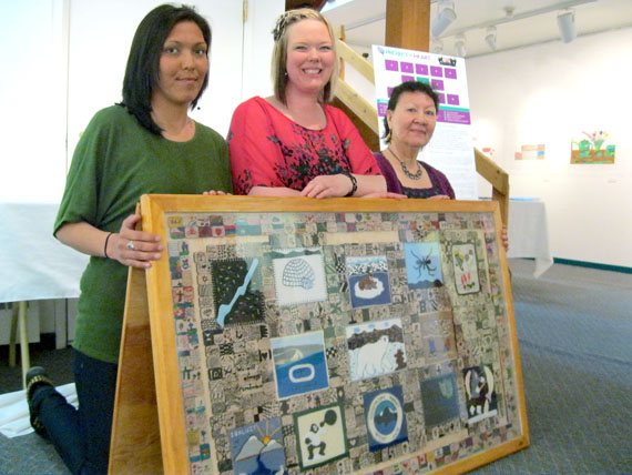 Cape Dorset Health workers Josie Taukie, Candice Waddell and Martha Jaw, left to right, brought the Project of Heart to Iqaluit’s Nunatta Sunakkutaangit Museum June 20. The framed work of tile and embroidery commemorates Nunavut residential school survivors. (PHOTO PETER VARGA)