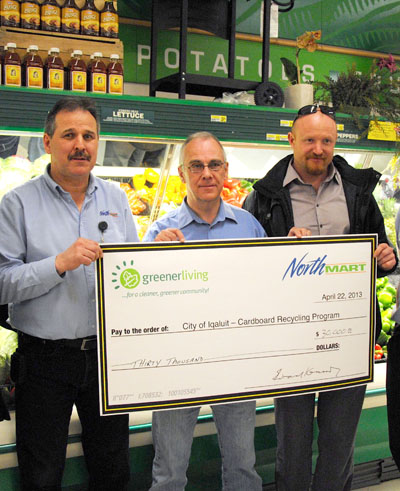 Northmart store manager Cliff Stringer, left, presented a $30,000 cheque to the City of Iqaluit in April, for environmental purposes. The unused funds resurfaced at a June 25 council meeting when Coun. Terry Dobbin reminded councillors about it. Mayor John Graham, centre, and Coun. Romeyn Stevenson collected the cheque with Dobbin at a brief ceremony held at Iqaluit’s Northmart store. (PHOTO COURTESY CITY OF IQALUIT)
