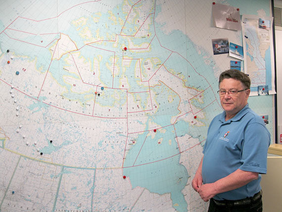 Jean-Pierre Lehnert heads up the Canadian Coast Guard’s Marine Communications and Traffic Services office in Iqaluit, which directs sea traffic in Canada’s Arctic for the entire eight-month shipping season. The office’s wall map shows all areas of Canada’s Arctic waters outlined in red. (PHOTO BY PETER VARGA)