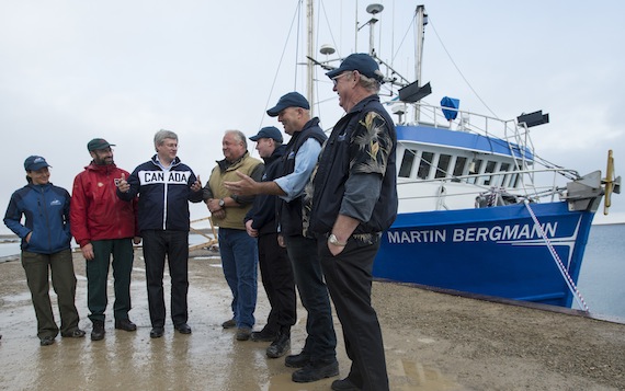 Prime Minister Stephen Harper chats with Captain Carrey Collinge and the crew of the Martin Bergmann research vessel prior to boarding the ship Aug. 22, 2012 in Cambridge Bay. (FILE PHOTO)