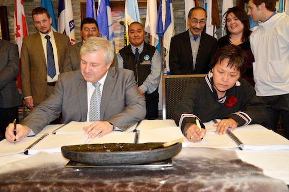 Baffinland's president and chief executive officer Tom Paddon (left) and Qikiqtani Inuit Association president Okalik Eegeesiak (right) sign an Inuit impact and benefit agreement and a commercial production lease Sept. 6 in Iqaluit. (PHOTO BY DAVID MURPHY) 
