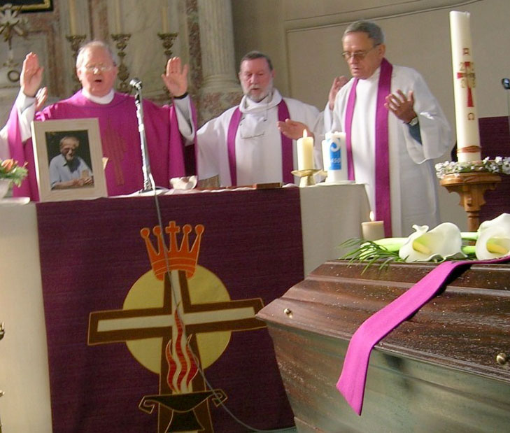 Father Eric Jose Dejaeger, standing in the middle, co-celebrating a funeral mass in 2009 with two other priests inside a church in Belgium, where he evaded arrest for 15 years on sex charges from Igloolik that were laid in 1995. His trial on those and numerous additional sex charges is set to start this week at the Nunavut Court of Justice building in Iqaluit. 