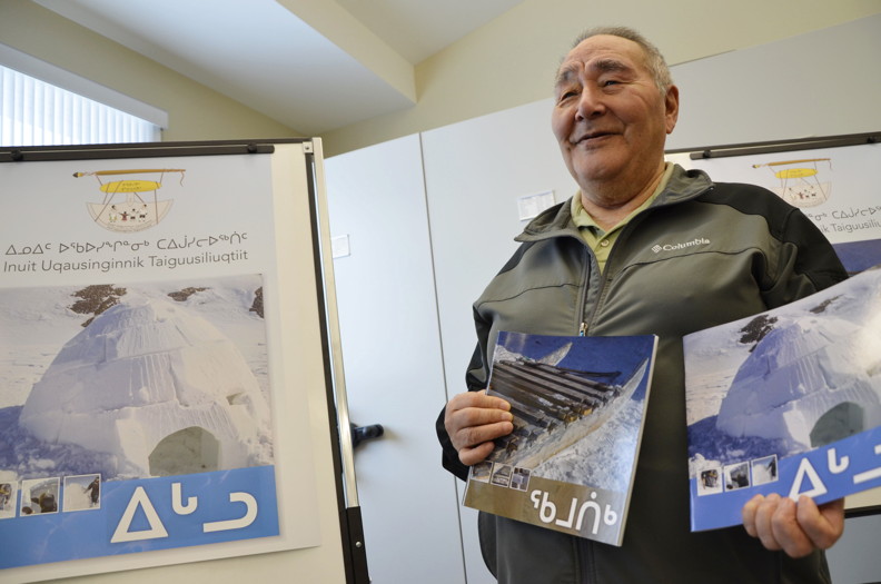 Elijah Erkloo, chairperson of Inuit Uqausinginnik Taiguusiliuqtiit, the Government of Nunavut's Inuit Language Authority, holds up two books on how to build an Igloo and Qamutik, and all the Inuktut terminologies used to describe the two. The book launch, held at the Nunavut Research Institute's library in Iqaluit Feb. 26, drew about 10 people who also enjoyed a traditional meal. (PHOTO BY DAVID MURPHY) 