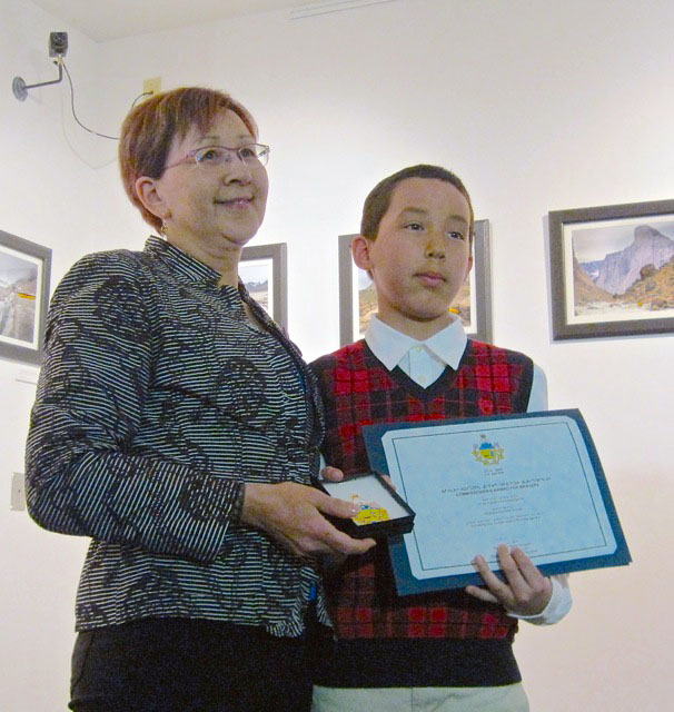 Deputy commissioner Nellie Kusugak poses with Amaujaq Groves at an April 17 ceremony in Iqaluit. Groves received a commissioner's award for bravery for helping his baby sister while she choking. (PHOTO BY PETER VARGA)