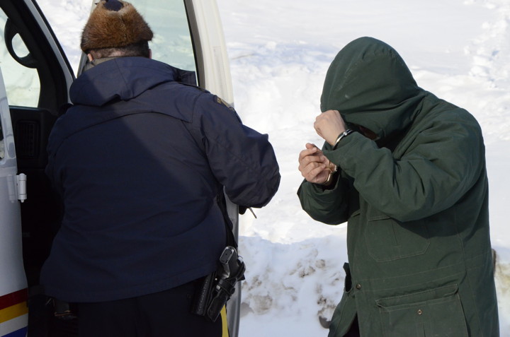 Billy Iblauk covers his head as he is escorted from the Nunavut Court of Justice. (FILE PHOTO)