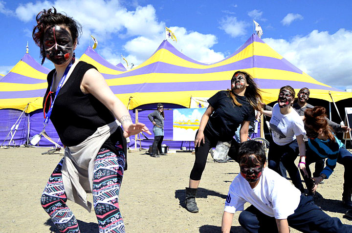Kathleen Merritt, left, and a gang of Greenlandic mask dancers, terrorize the general public outside Alianait's big top tent June 30. The group danced their way onto the street, frightening pedestrians and grabbing the attention of passing motorists. The ancient practice, which incorporates fear and humour, is still popular among Inuit on the east coast of Greenland. (PHOTO BY DAVID MURPHY) 

