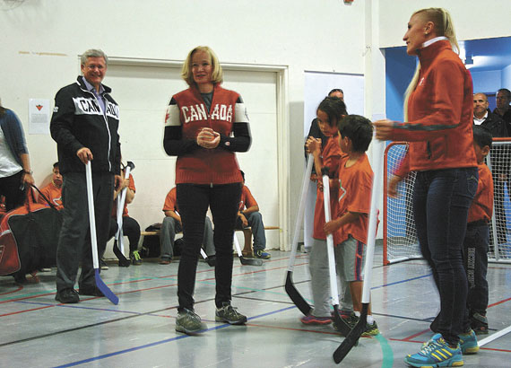 Laureen Harper lines teams up for the opening face-off of a floor hockey game at Nakasuk School in Iqaluit with her husband, Prime Minister Stephen Harper, left, who joined in the play. The quick game concluded an afternoon of activities, Aug. 25, in support of sports and recreation. (PHOTO BY PETER VARGA)