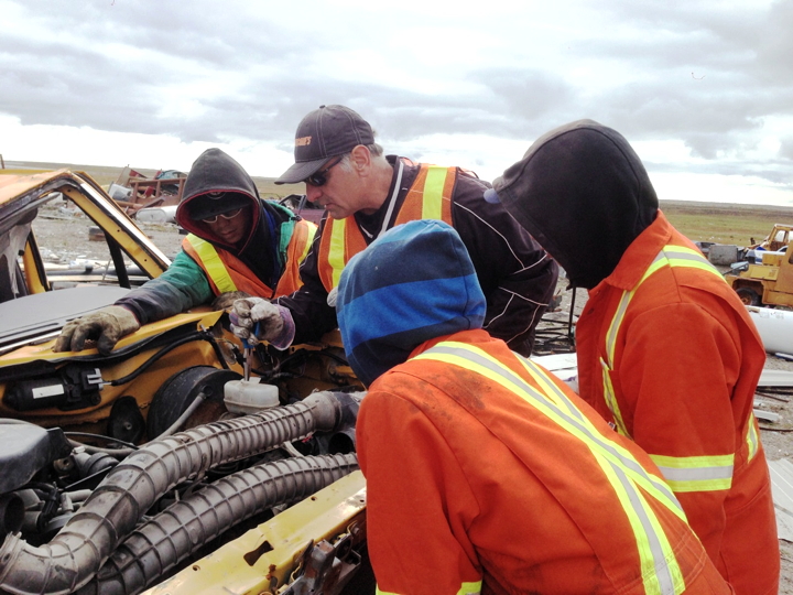 Claudio Russo of Automotive Recyclers of Canada shows trainees in Arviat how to remove hazardous waste from a derelict vehicle in Arviat this summer. (PHOTO COURTESY SUMMERHILL IMPACT)