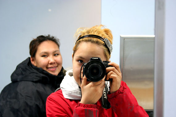 Barbara Okpik focuses her camera on a mirror at Gjoa Haven's community hall on Nunavut Day, July 9, while Erica Tungilik watches. Okpik and Tungilik are involved in the Nanivara history project, taking place this summer in their home community and in Naujaat. Read more about the project on Nunatsiaqonline.ca. (PHOTO COURTESY OF NANIVARA)