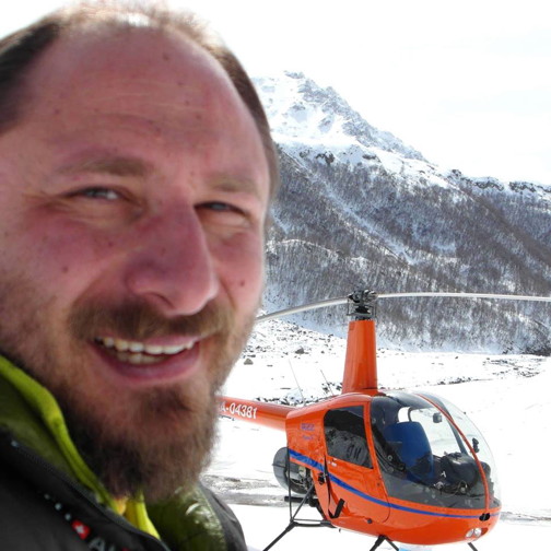 The globe-trotting Russian pilot Sergey Ananov with his helicopter, a two-seater Robinson R-22. The aircraft went down with mechanical failure July 25 over Davis Strait but Ananov was rescued and made his way to Iqaluit aboard the CCGS Pierre Radisson. (IMAGE FROM R22RTW FACEBOOK PAGE) 