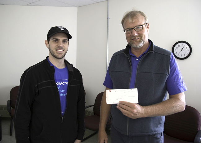 Mark Aspland, left, presents John Vander Velde, treasurer of the Kamatsiaqtut Help Line in Iqaluit, with a $3,000 cheque on June 26. Aspland has sold more than 150 photos and videos in an effort to raise funds for the help line. (PHOTO COURTESY MARK ASPLAND)