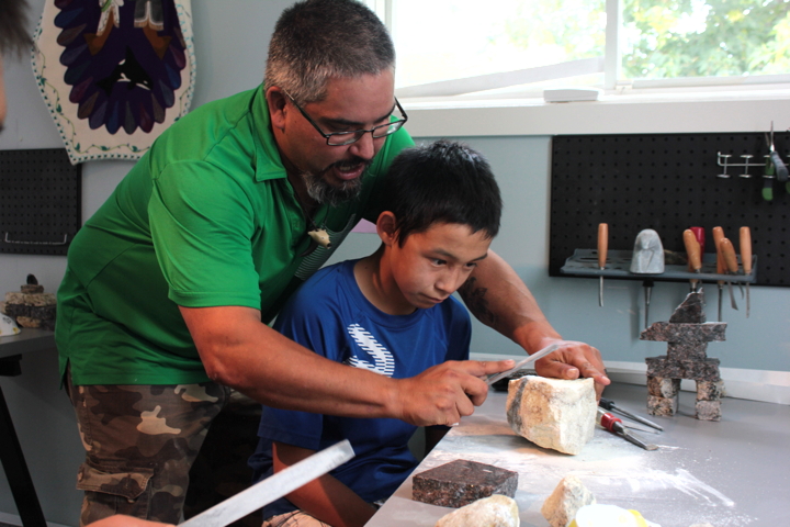 Facilitator Dion Metcalfe shows Neil Evaglok how to file down stone manually. (PHOTOS BY LISA GREGOIRE)