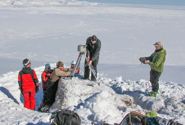 A team from Oceans North Canada installs the second of two cameras on cliffs overlooking Eclipse Sound near Pond Inlet recently. The team is hoping to get time-lapse images of the floe edge as it recedes in spring to see how the ice behaves. They want to be able to compare how the ice acts naturally prior to any ice-breaking in the Sound. Baffinland Iron Mines, which runs the Mary River iron mine in North Baffin, is proposing to ship iron ore out of Milne Inlet and through Eclipse Sound 10 months of the year with the aid of icebreakers. That proposal is currently undergoing an environmental assessment with the Nunavut Impact Review Board. See story on Nunatsiaqonline. ca. (PHOTO BY TREVOR TAYLOR)