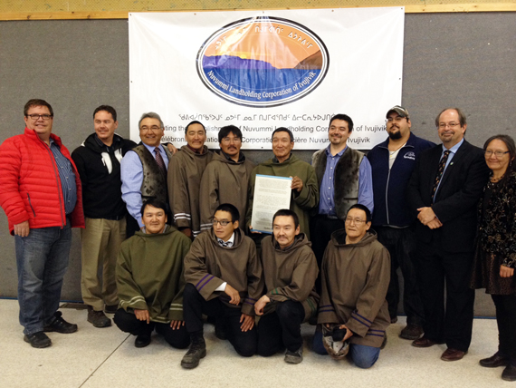 Adamie Kalingo, president of the new Nuvummi Landholding Corp. centre, holds up the letters patent that marks the transfer of Category 1 lands to his community July 20. Surrounding Kalingo, in brown, local landholding directors, Makivik Corp. executives and two Quebec MNAs. (PHOTO COURTESY OF JEAN BOUCHER) 
