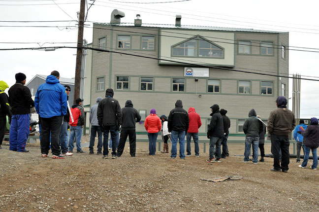 About 25 striking workers from the Qulliq Energy Corp. shout chants and slogans at the QEC office building in Iqaluit on the morning of July 29. Unionized workers from Nunavut's energy company walked off the job at midnight July 16 so today is the two-week mark. Neither side has shown any sign yet of coming back to the negotiating table. (PHOTO BY THOMAS ROHNER)