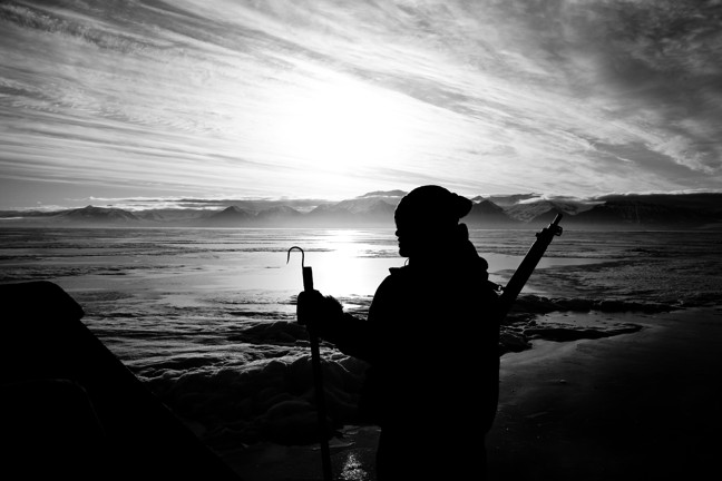 Bryan Simonee, in silhouette with seal hook, in June 2014 during filming of 