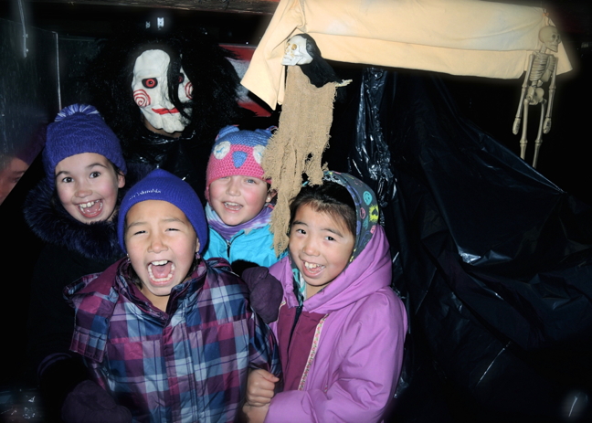 I'm not scared, are you scared? Nunavik youngsters brave a haunted house in Kuujjuaq Oct. 28 as part of a spooky, and popular, annual Halloween tradition at Kuujjuaq's Uvikkait Dome Youth Centre. Children five to nine years old lined up Wednesday for an opportunity to sneak through a pitch black maze populated with hanging decorations and staff members dressed up as goblins and monsters, like this character Jigsaw from the movie Saw. The haunted house will be open again after school today, Oct. 29, for children aged 10 to 14 and then Friday, Oct. 30, for youth 15 to 17. From left: Brianna Koneak, Louisa Gordon, Niivi Snowball and Eva Partridge. (PHOTO BY ISABELLE DUBOIS)