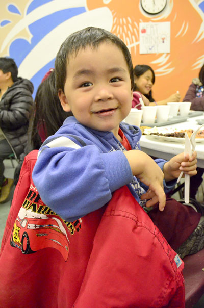 Little Aqiggik Angoyuak of Iqaluit gets ready to tuck into a tasty meal at the Iqaluit soup kitchen Oct. 17. Volunteers served up seal pie, mashed potatoes, salad and bannock. (PHOTO BY JIM BELL) 