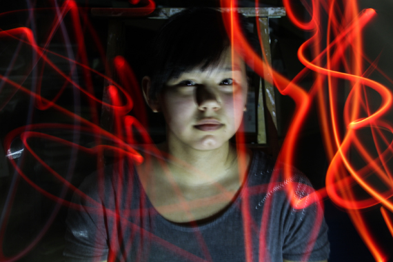 A portrait of Kangiqsujuaq student Annie-Caroline Palliser, framed with streaks of red light.