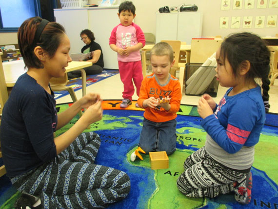 ECE student Masiva Pewatoalook, left, plays with preschoolers Richard Beckett Haworth (in orange) and Leetia Peterloosie, far right, at Pond Inlet's new Piruvik preschool, which just opened its doors Jan. 14. (PHOTO BY TESSA LOCHHEAD) 
