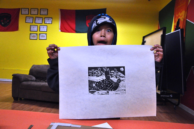 Moe Kelly, 11, shows off a print made from his own etching of a seal-duck hybrid animal in a workshop held at the Cape Dorset arena March 30. The Embassy of Imagination, led by Patrick Thompson and Alexa Hatanaka, is back in Cape Dorset this winter with a series of arts workshops to be held over three months. (PHOTO BY THOMAS ROHNER)