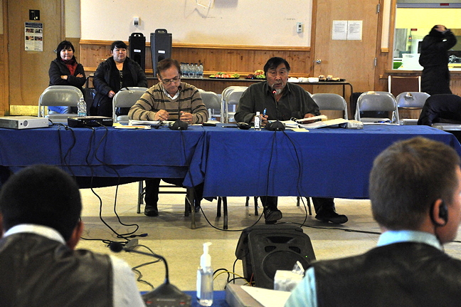 Scott Wells, the Qikiqtani Inuit Association's director of finance, left, and Joe Attagutaluk, QIA's secretary treasurer, deliver their financial reports to QIA board members and members of the public Oct. 4 at the Inuit organization's annual general meeting in Iqaluit. (PHOTO BY THOMAS ROHNER)