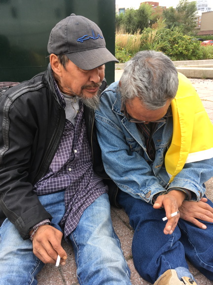 Manasie Ikalukjuak, left, and Silas Qayaqjuaq, friends of the late Annie Pootoogook, share stories and tears near the Shepherds of Good Hope homeless shelter in Ottawa's Byward Market. (PHOTO BY COURTNEY EDGAR)