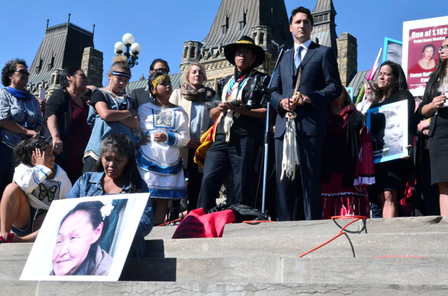 Prime Minister Justin Trudeau speaks at a Sisters in Spirit rally held to raise awareness about Missing and Murdered Indigenous Women on Parliament Hill Oct. 4 where many people honoured the memory of Annie Pootoogook, in photograph, bottom left. (PHOTO BY JIM BELL)