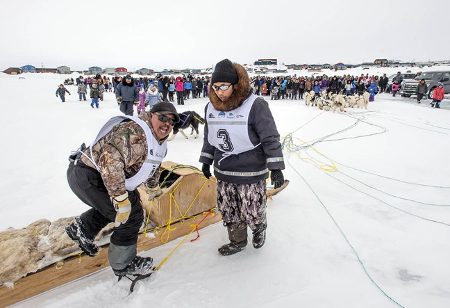 Puvirnituq musher Peter Ittukallak, left, and partner Putugu Iqiquq, were the first to arrive in Inukjuak March 31, day four of Nunavik's annual Ivakkak dog sled race. As of that day, Ittukallak and Iqiquq were in third place overall, about 45 minutes behind frontrunners Willie Cain and Putulik Saunders of Tasiujaq. This year's race course takes mushers along the Hudson Bay coast from Umiujaq and Ivujivik, which appears to be about 700 kms by map. Racers planned to stay in Inukjuak over the weekend for a community feast and memorial celebration for former Ivakkak champion Adamie Inukpuk. Bad weather prevented the teams from departing Sunday, April 3 so mushers took off April 3. The annual race, which celebrates the Inuit sled dog tradition, usually takes between 10 days to two weeks to complete. (PHOTO BY PIERRE DUNNIGAN/MAKIVIK)