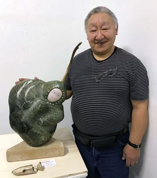 Iyaituk poses with the carving he created during a month-long residency at the École nationale superiére des beaux-arts de Paris, a renowned French art school. (PHOTO COURTESY OF M. IYAITUK)