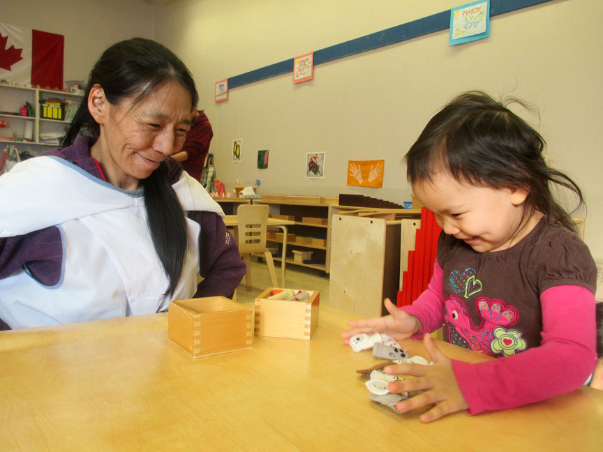 Leah Kippomee, a recent graduate of the Early Childhood Education program offered by Nunavut Arctic College learning centre in Pond Inlet, helps preschooler Sonia Rae Enookolo work with finger puppets. Kippomee and five other student recently graduated with two-year ECE diplomas and some will seek jobs at the Pirurvik pre-school in Pond Inlet. (PHOTOS COURTESY OF TESSA LOCHHEAD)