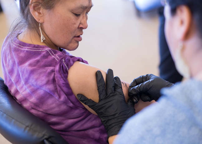 Hovak Johnston works on a tattoo for Millie Angulalik in Kugluktuk in the spring of 2016. The Inuit tattoo artist is releasing a book with Inhabit Media that documents the tattoo project she led in the western Nunavut community. (PHOTO BY CORA DEVOS)