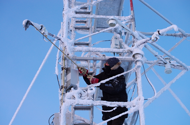 PEARL operator Peter McGovern cleans frost from instruments on a 10-metre-high flux tower. The tower measures properties in the atmosphere. (PHOTO BY PIERRE FOGAL)
