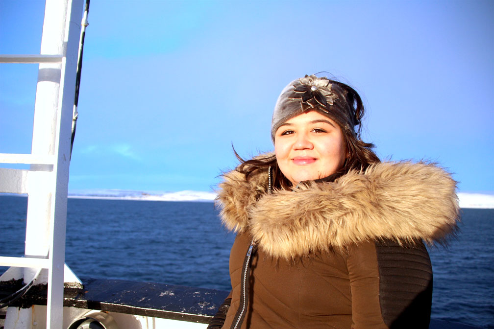 Kerry Ningeocheak of Coral Harbour enjoys a bit of sunshine near the bow of the CCGS Henry Larsen near the end of her day-long tour. If she is hired to work for the Coast Guard, she says she could act as a translator during community visits to the North. (PHOTO BY BETH BROWN)
