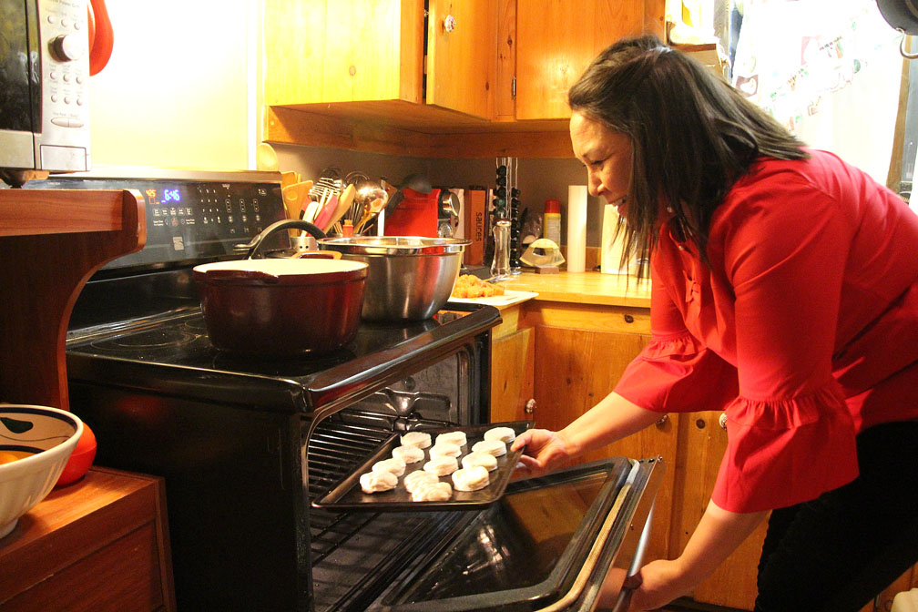 Sheila Lumsden puts her yummy bannocks into the oven. You can find her bannock recipe near the end of this story. (PHOTOS BY BETH BROWN)