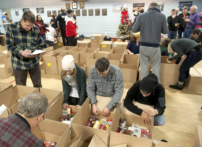 Iqalungmiut help to fill up Christmas hampers during a food drive hosted annually by the Iqaluit Rotary Club. You can come out on Saturday, Dec. 16, to help make the event a success again this year. (PHOTO BY JOHN MATTHEWS)
