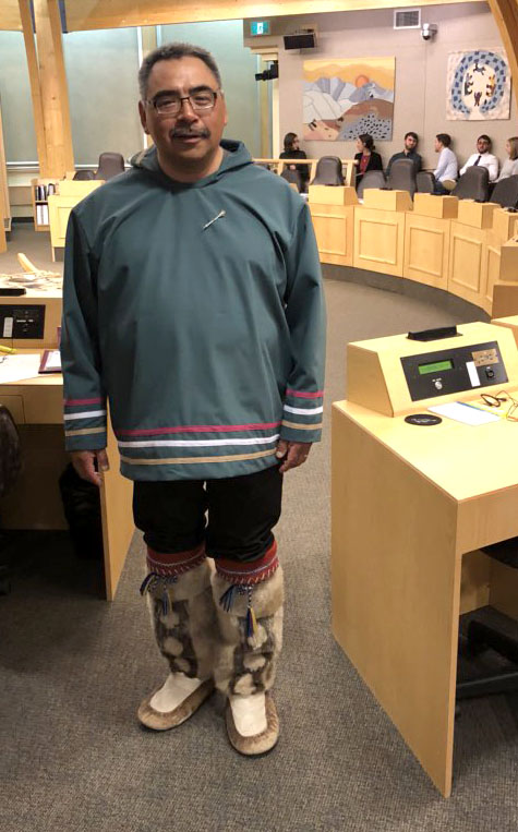 Nunavut Finance Minister David Akeeagok stands in the legislature after delivering his budget address Monday afternoon, wearing a new silapak his wife just made and sealskin kamiks his mother made 44 years ago, and which Akeeagok received from a man who bought them from his mother. (PHOTO BY JANE GEORGE)