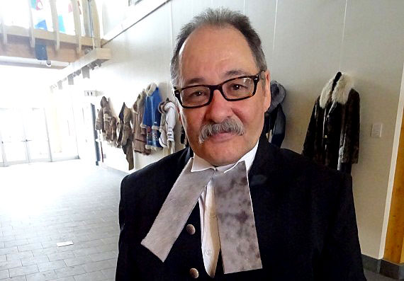 Nunavut Speaker Joe Enook stands in the foyer of the Nunavut legislature while wearing an outfit with some new touches: a sealskin tie and caribou-bone buttons. These were added by Iqaluit designer Nicole Camphaug, known for her sealskin creations, who is also an employee of the legislative assembly. (PHOTO BY JANE GEORGE)