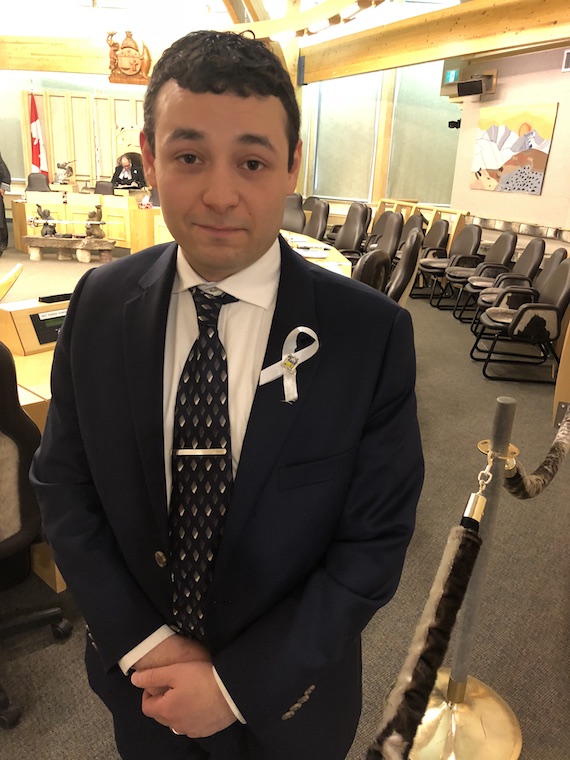 Nunavut MLA Adam Arreak Lightstone, who represents the riding of Iqaluit-Manirajak, stands in the territorial assembly chamber on June 7, the seventh anniversary of the violent death of his sister Sula Enuaraq, along with that of her two daughters. You can see the white lapel ribbon, a symbol of the movement of men and boys against domestic violence. (PHOTO BY JANE GEORGE)