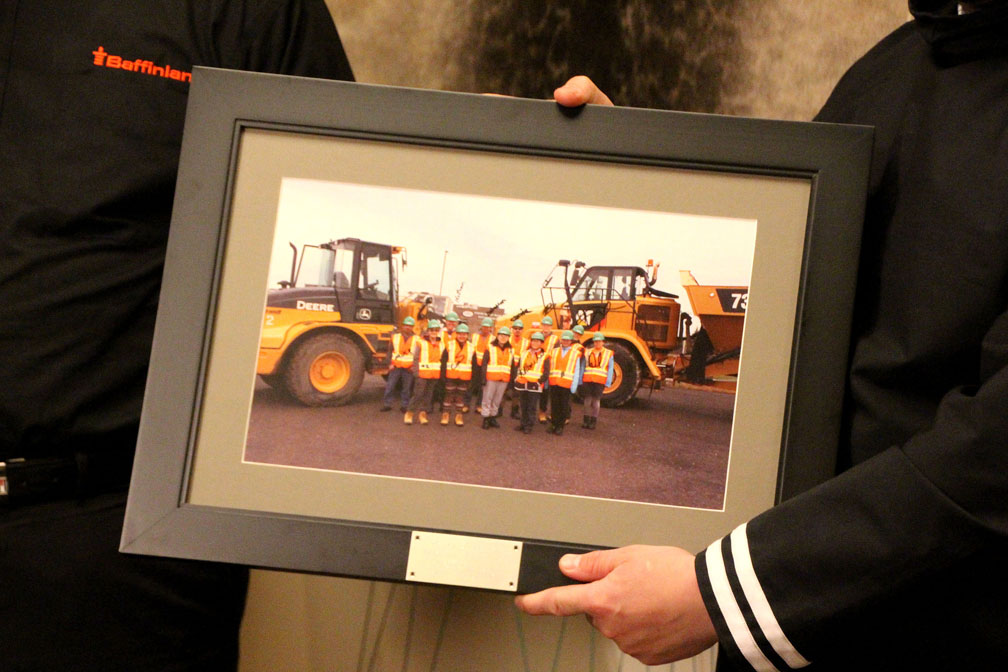 At a signing ceremony held on Oct. 3 for their amended Inuit impact and benefits agreement, Brian Penney, the president and CEO of Baffinland Iron Mines Corp., and P.J. Akeeagok, the president of the Qikiqtani Inuit Association, display a photo of Inuit heavy-equipment trainees who have benefited from a training program recently struck between QIA and the company. QIA, along with the Hamlet of Pond Inlet and the Mittimatalik Hunters and Trappers Organization, told Northern Affairs Minister Dominic LeBlanc that such training programs would be threatened if the Mary River iron mine cannot increase its production. (PHOTO BY BETH BROWN)